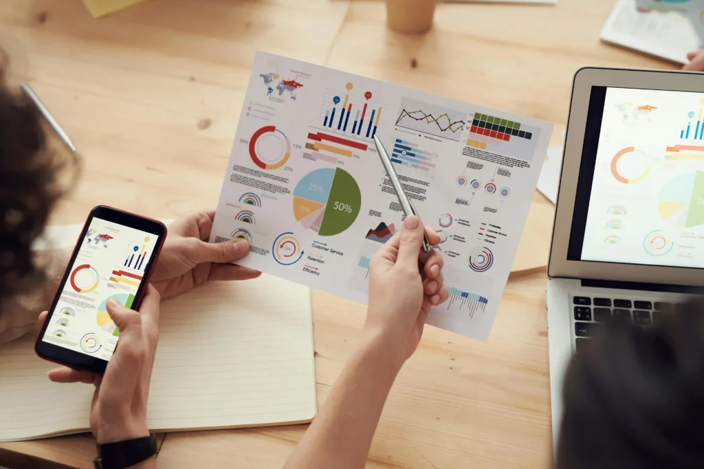 top digital marketing strategist in kerala This image depicts a close-up of a collaborative work session focused on data analysis or performance tracking